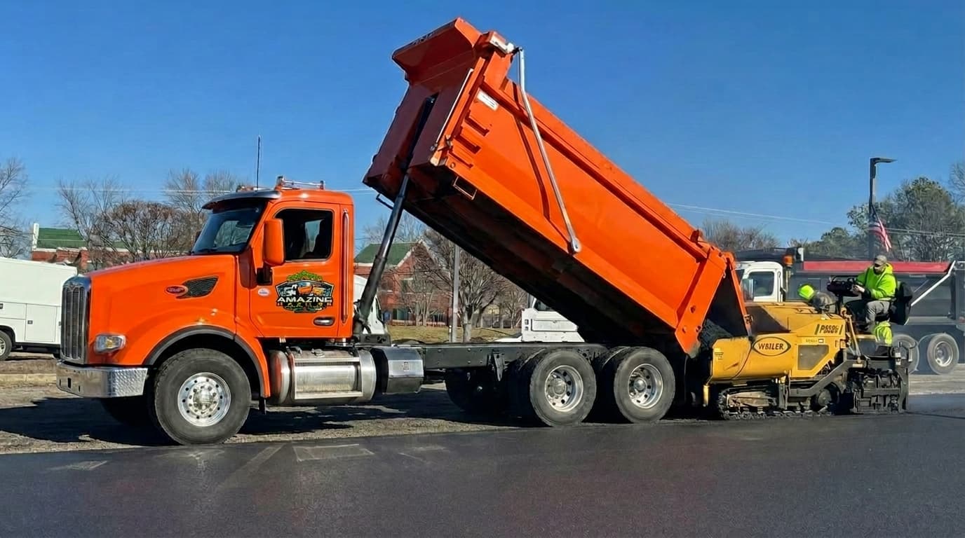 Asphalt paving crew supported by hauling services